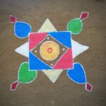 Vibrant geometric rangoli design on brown textured surface, showcasing Indian folk art and cultural heritage.