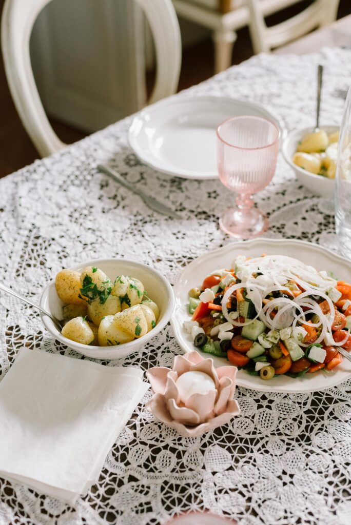Charming dining setting with a fresh salad and boiled potatoes, perfect for spring gatherings.