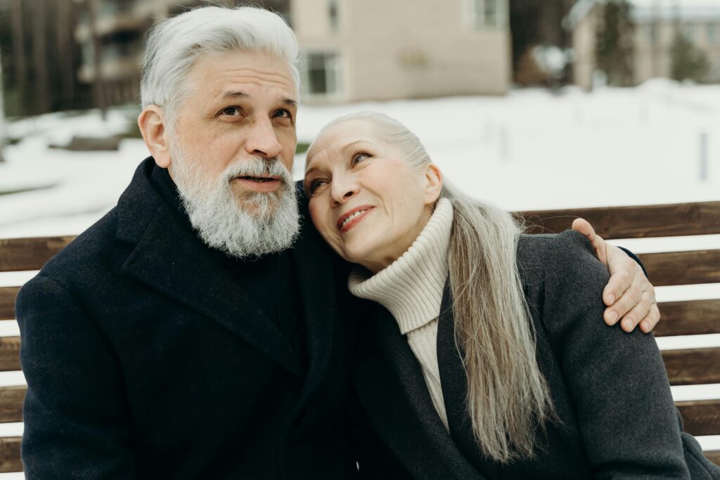 Senior couple sharing a heartfelt embrace outdoors during winter.