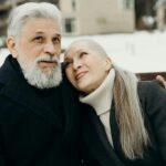 Senior couple sharing a heartfelt embrace outdoors during winter.