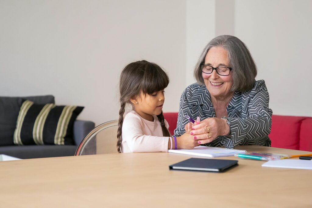 Elderly woman joyfully engaging with her grandchild, displaying bonding and happiness.