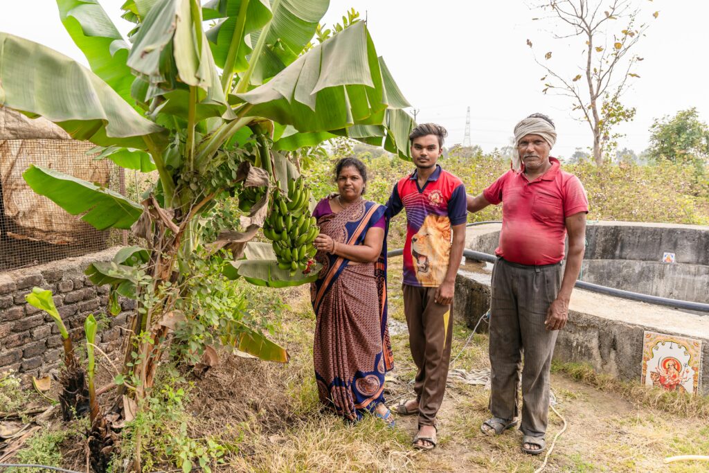 A family of farmers in Nagpur, India, harvesting bananas in a rural setting.