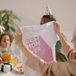 A joyful indoor Mother's Day celebration featuring a family with a 'Best Mom Ever' shirt.