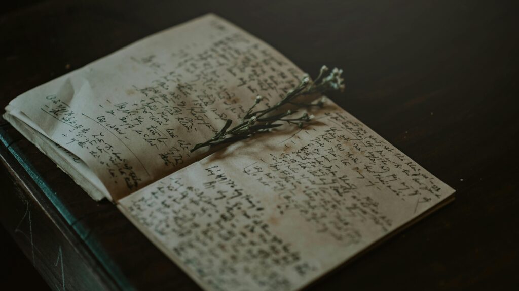 A vintage notebook with handwritten notes and delicate flowers, evoking nostalgia and warmth.