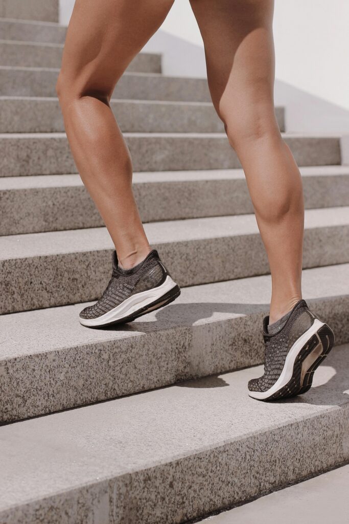 Dynamic shot of athletic legs in sneakers climbing stairs, perfect for fitness and lifestyle themes.