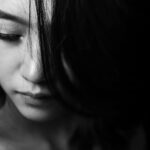 Monochrome close-up of a young woman with a thoughtful expression, emphasizing emotions.
