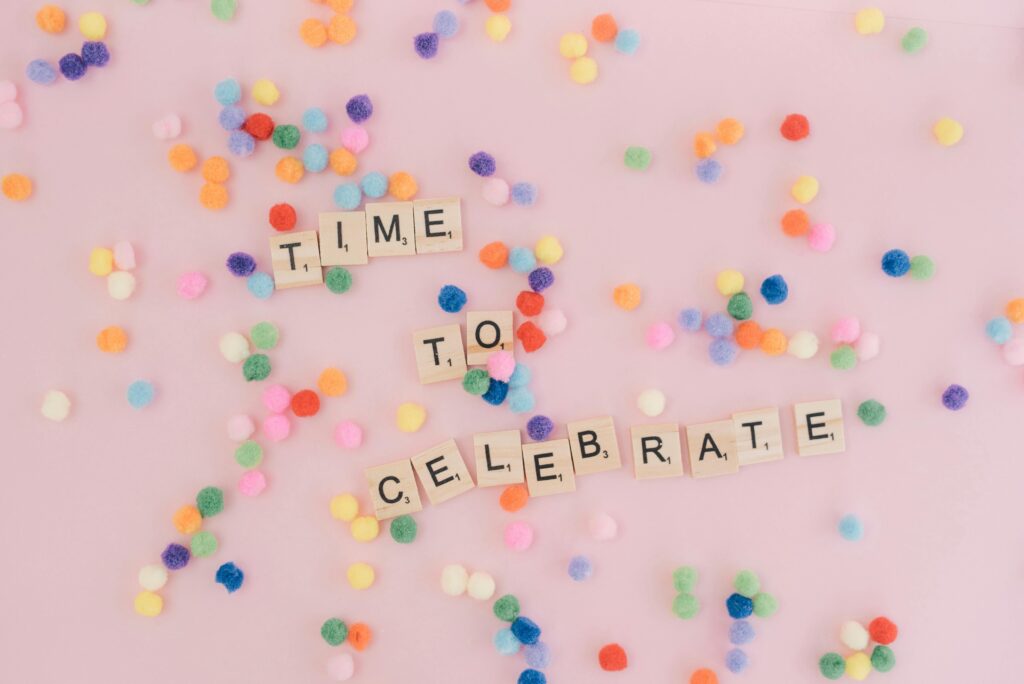 Bright and cheerful celebration concept with colorful confetti and scrabble tiles spelling 'Time to Celebrate'.