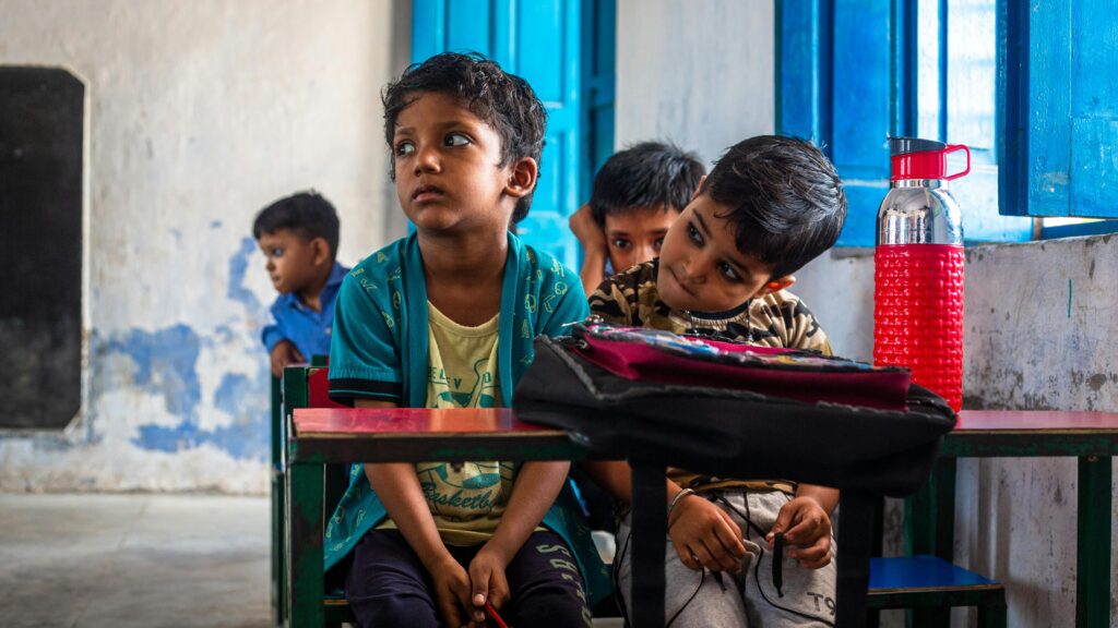 Joyful Indian children sitting in a colorful classroom, engaged and curious.