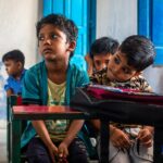 Joyful Indian children sitting in a colorful classroom, engaged and curious.