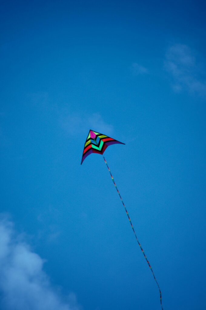 A vibrant kite flies against a backdrop of vibrant blue sky, symbolizing freedom and adventure.
