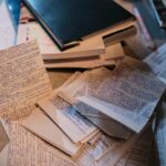 Scattered handwritten notes and books on a desk, perfect for study or research themes.