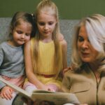 A loving grandmother reading with her two young granddaughters at home, sharing a special bonding moment.