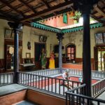 Interior view of a traditional Indian courtyard with wooden columns and railings, showcasing cultural heritage.