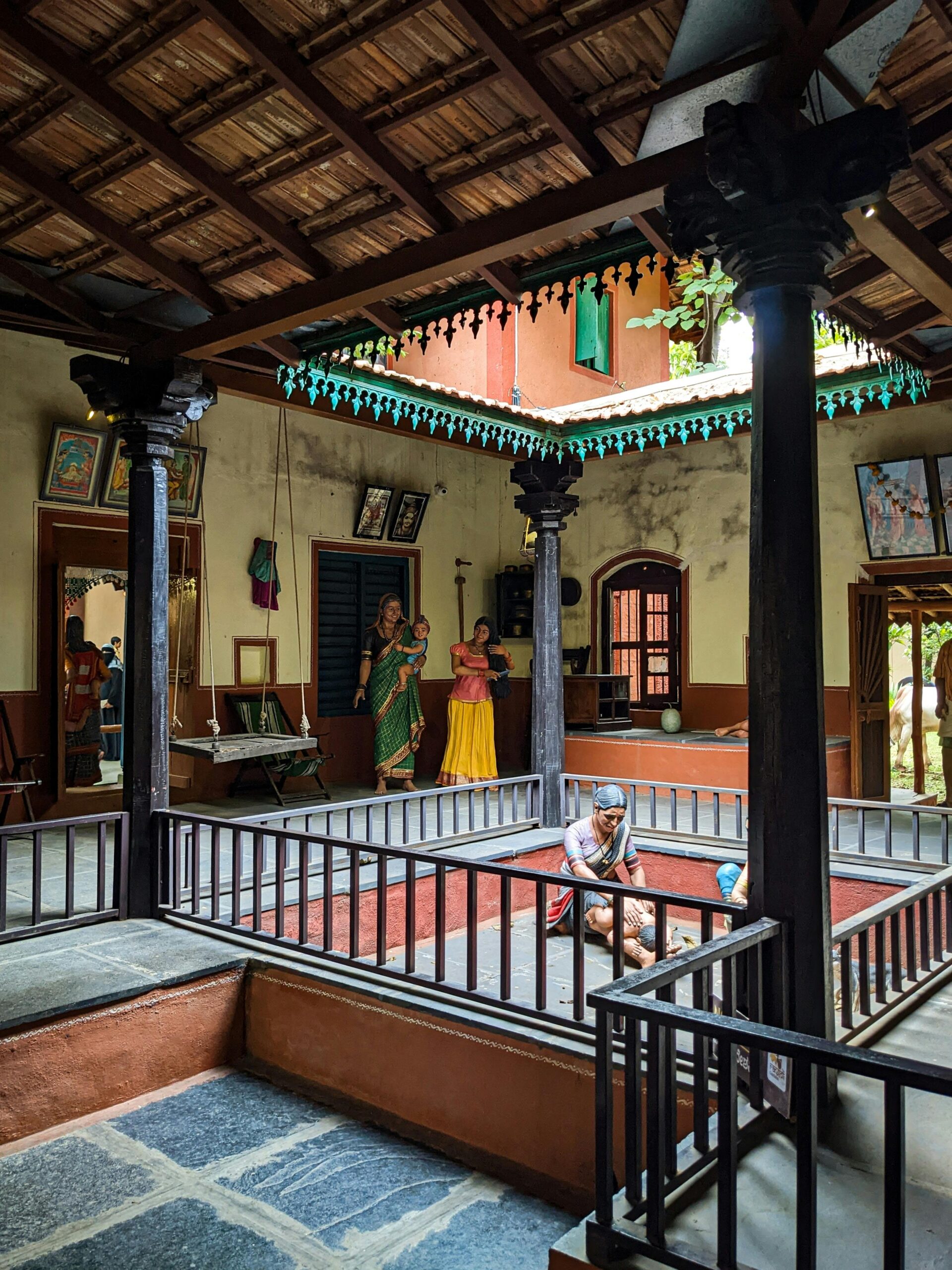 Interior view of a traditional Indian courtyard with wooden columns and railings, showcasing cultural heritage.