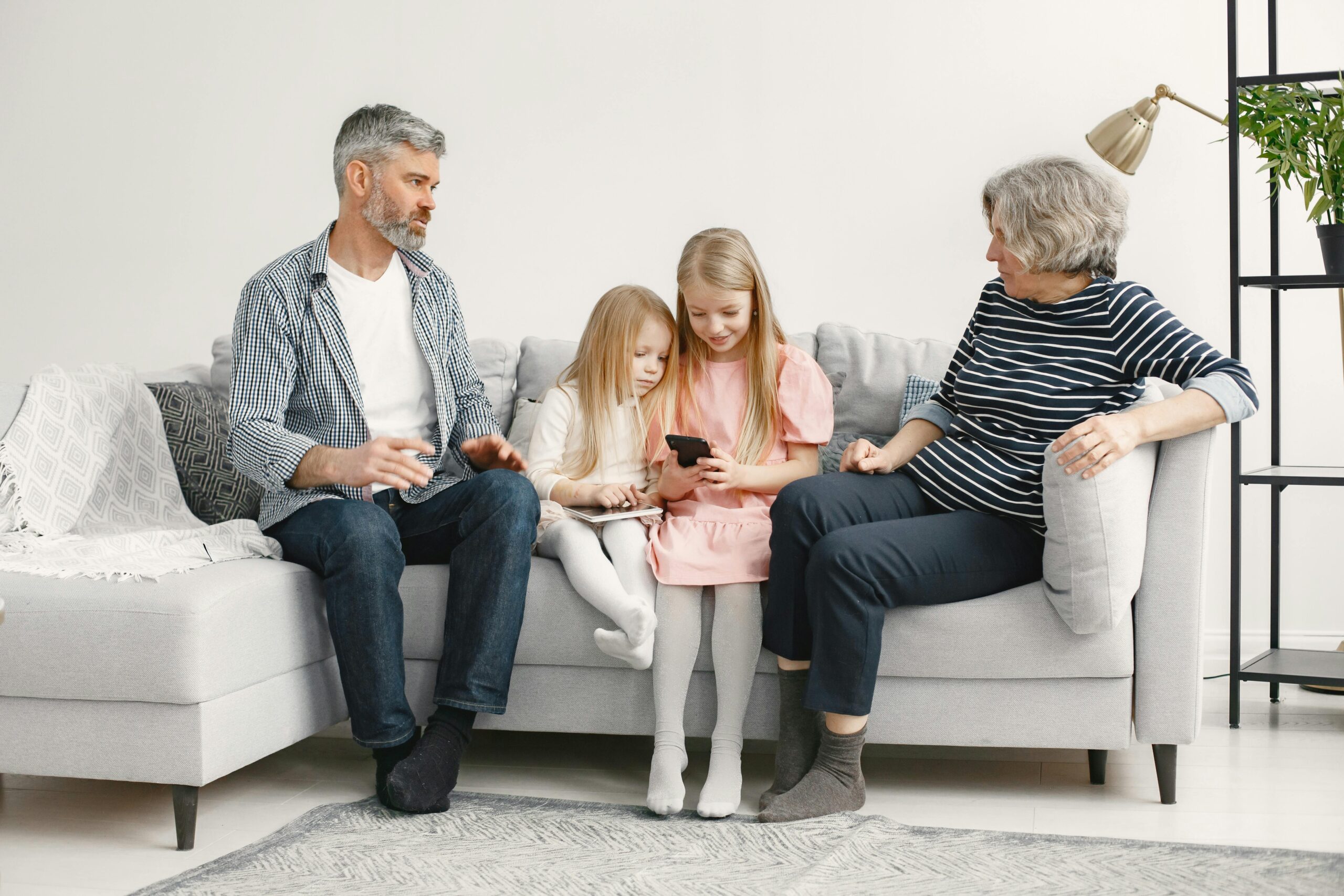 A joyful family enjoys quality time together on a cozy living room couch.